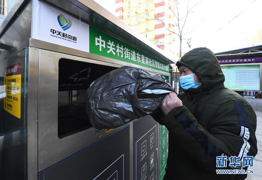 1月18日，在北京市海淀区中关村街道东里南社区智能垃圾分拣站，社区居民投放垃圾。近期，北京市海淀区中关村街道通过引入智能垃圾分拣站、垃圾分类监管平台两个试点助力垃圾分类。据了解，智能垃圾分拣站可通过红外感应、机械手等设备实现厨余垃圾整包投放、免手动破袋等功能。垃圾分类监管平台可实时了解社区居民投放垃圾情况，如遇到社区居民垃圾投放不规范，该平台可通过设置在垃圾驿站的语音提示系统进行提示。新华社记者 任超 摄