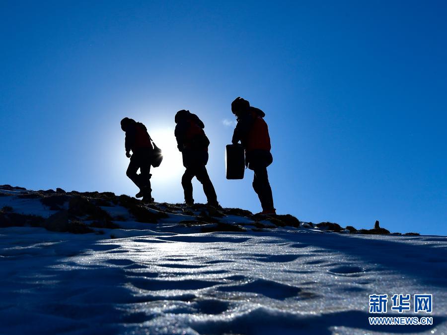 　　1月21日，国家电网西宁供电公司输电运检中心运检人员在登山巡检。新华社记者 张龙 摄
