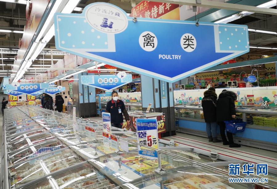 1月24日，在哈尔滨市香坊区一家大型超市，一名工作人员走向禽类冷冻冷藏冰柜区（手机照片）。新华社记者 王建威 摄