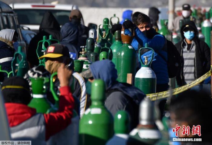 当地时间7月23日,秘鲁第二大城市阿雷基帕,新冠肺炎患者的家属排队给医用氧气瓶充电。 点击进入下一页