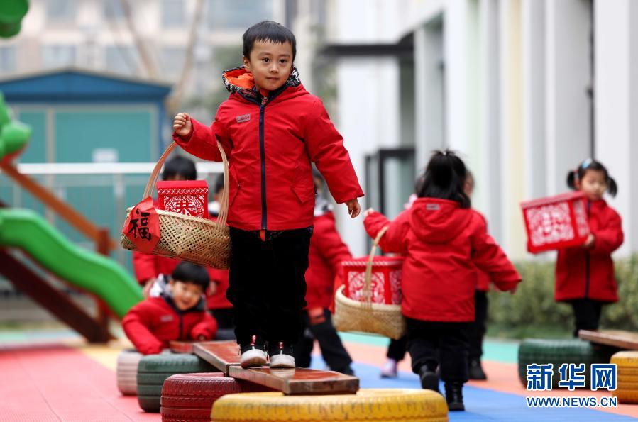 　　1月27日，孩子们在参加“过独木桥送年货”游戏。　　当日，安徽省合肥市瑶海区一幼儿园开展民间体育游戏运动会，孩子们参加“滚铁环”“踩高跷”“独木桥”等传统游戏，在锻炼身体的同时，感受传统文化的魅力。　　新华社发（解琛 摄）