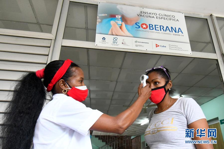 　　1月28日，在古巴首都哈瓦那一处综合诊所，医务人员为接种疫苗的志愿者测量体温。新华社发（华金·埃尔南德斯 摄）
