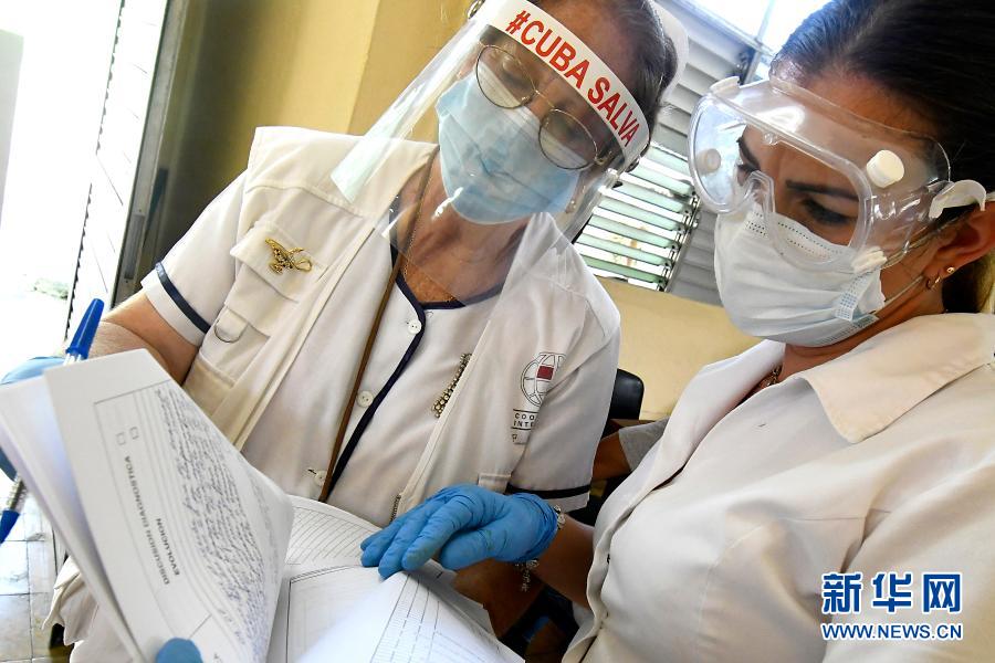 　　1月28日，在古巴首都哈瓦那一处综合诊所，医务人员查看疫苗临床试验相关文件。新华社发（华金·埃尔南德斯 摄）