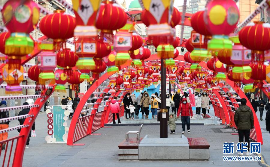 2月1日，在沈阳中街，市民从花灯下走过。春节临近，年味渐浓，在辽宁沈阳中街步行街，福牛艺术雕塑和各色花灯吸引了众多市民观看拍照。新华社记者 杨青 摄