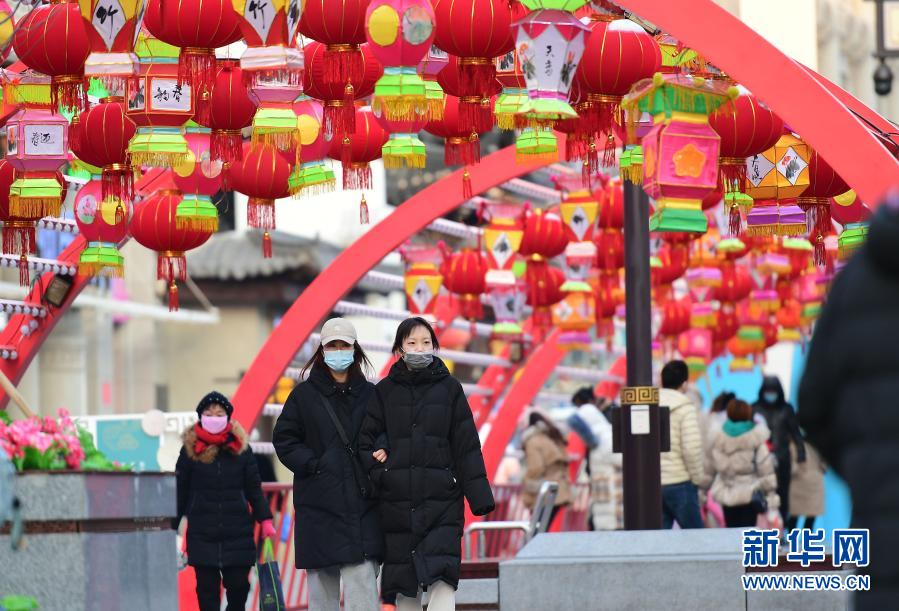 2月1日，在沈阳中街，市民从花灯下走过。春节临近，年味渐浓，在辽宁沈阳中街步行街，福牛艺术雕塑和各色花灯吸引了众多市民观看拍照。新华社记者 杨青 摄