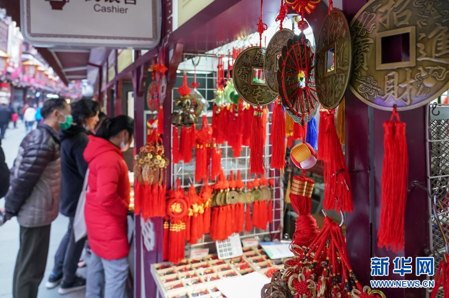 　　2月7日，市民在上海豫园选购节庆饰品。　　春节将至，上海市节日氛围日渐浓厚。人们纷纷外出感受春意，采购年货，迎接新年。　　新华社记者 王翔 摄