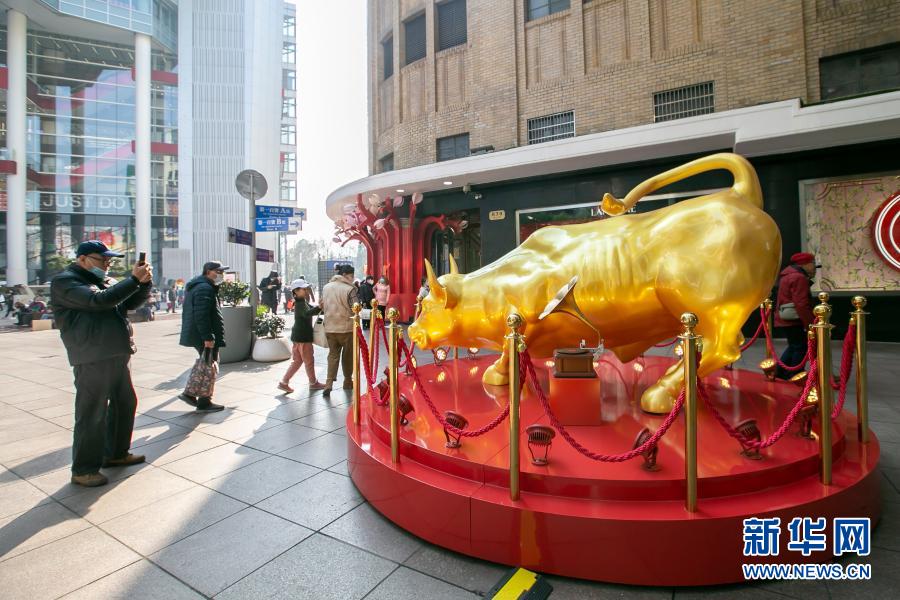 　　2月7日，市民在南京路步行街旁拍摄金牛雕塑。　　春节将至，上海市节日氛围日渐浓厚。人们纷纷外出感受春意，采购年货，迎接新年。　　新华社记者 王翔 摄