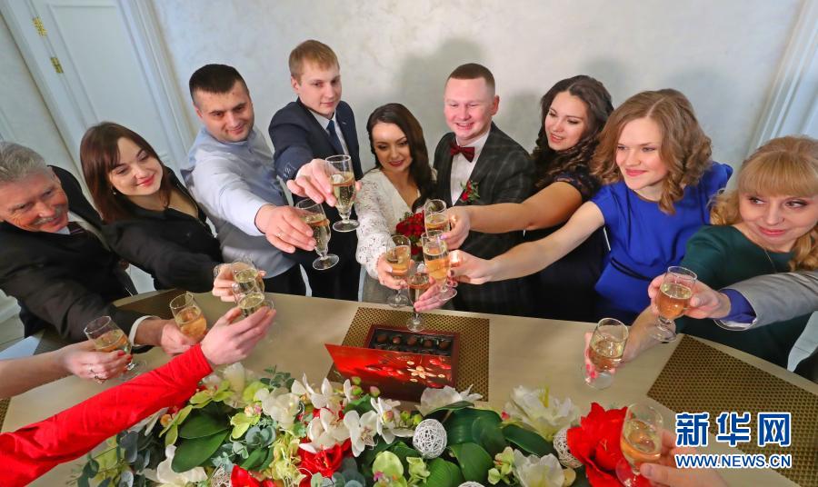 2月12日，在白俄罗斯首都明斯克，一对刚办理婚姻登记的年轻人与亲友举杯庆祝。2021年2月12日用日月年的日期排列顺序是“12022021”，被认为是今年的“对称日”。当日，很多白俄罗斯情侣登记结婚，希望能够带来好运。新华社发（任科夫摄）
