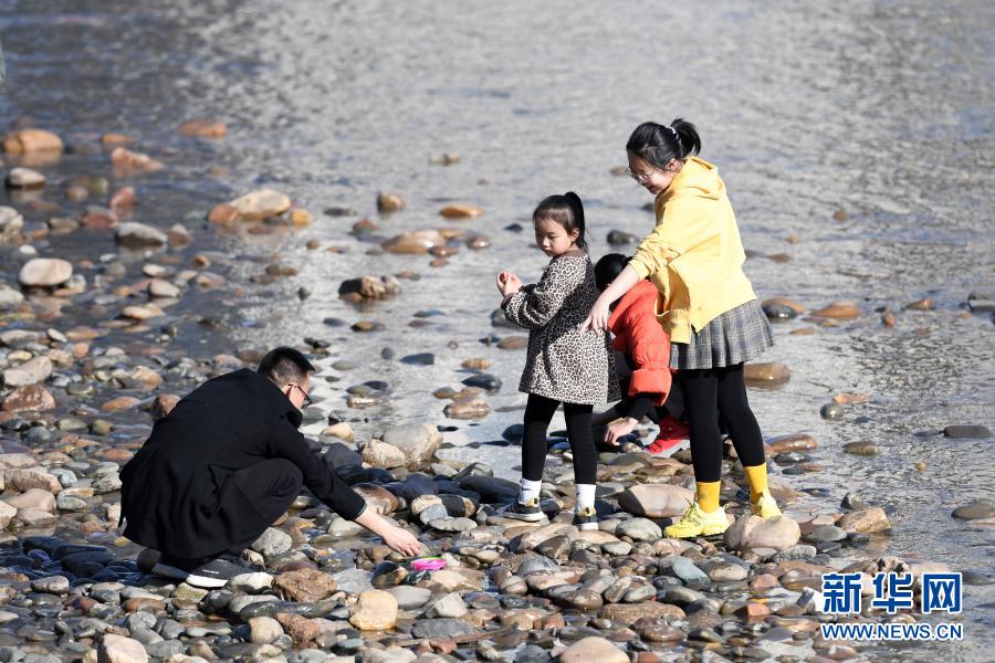 　　2月18日，市民带着孩子在黄河兰州段河床上捡石头。　　近日，受黄河上游来水量较少等因素影响，黄河兰州段水位持续下降，部分河床裸露，又恰逢气温回暖，众多市民带着孩子来到黄河边休闲游玩。　　新华社记者 范培珅 摄