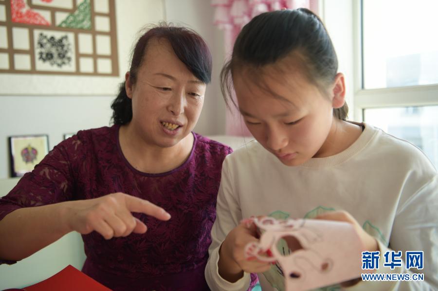 　　2月21日，在乌海市海南区新桥花园，李华（左）在家中指导外孙女高宇晨剪纸。　　今年56岁的李华家住内蒙古自治区乌海市海南区新桥花园，受长辈影响从小就开始剪纸。在李华引导下，她的大女儿谭红叶也爱上了剪纸，经常与李华探讨创新剪纸技艺的想法。现在，李华的外孙女高宇晨也向她们学习剪纸技艺，已经能独立创作剪纸作品。　　李华坚持剪纸40多年，创作了丰富的剪纸作品。为了传承剪纸技艺，李华除了教授女儿、外孙女剪纸，还参加剪纸展览、教学等活动，带动更多的人学习、传承剪纸技艺。　　今年春节，李华一家三代人一起剪纸，用不同的作品迎接新春。“我想通过我们三代人的接力，带动亲人朋友学习剪纸，让剪纸技艺传承下去。”李华说。　　新华社记者 李志鹏 摄