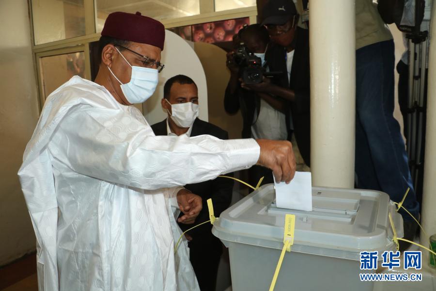 　　2月21日，尼日尔争取民主和社会主义党候选人穆罕默德·巴祖姆（前）在尼亚美的一处投票站投票。新华社发