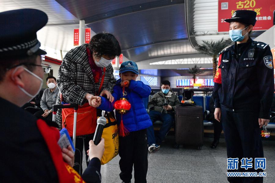 2月26日，在天津站候车厅，天津站派出所民警为出行旅客送上节日礼物。当日是农历正月十五元宵节，北京铁路公安局天津铁路公安处与天津站派出所共同在天津站候车厅里举办了一场“猜灯谜、迎元宵”的节日活动，为即将踏上旅途的旅客们送上节日祝福、欢庆元宵佳节。新华社发（孙凡越 摄）