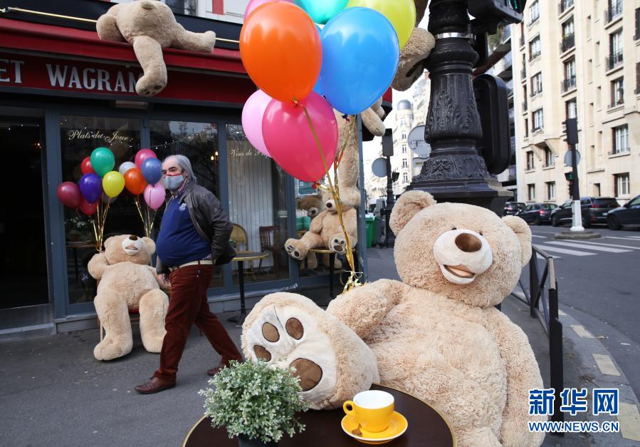 　　3月3日，一名男子走过法国巴黎街头一家餐馆外的玩具熊。新华社记者 高静 摄