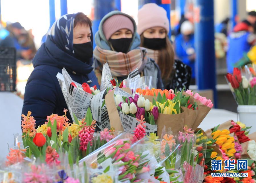 3月6日，一名女子在白俄罗斯首都明斯克展示刚刚选购的鲜花。当日，明斯克不少市民前往市场购买各类鲜花，迎接即将到来的“三八”国际劳动妇女节。　新华社发（任科夫摄）