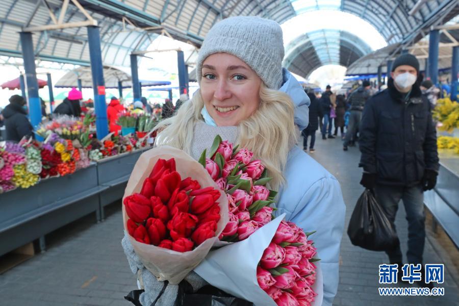 3月6日，一名女子在白俄罗斯首都明斯克展示刚刚选购的鲜花。当日，明斯克不少市民前往市场购买各类鲜花，迎接即将到来的“三八”国际劳动妇女节。　新华社发（任科夫摄）