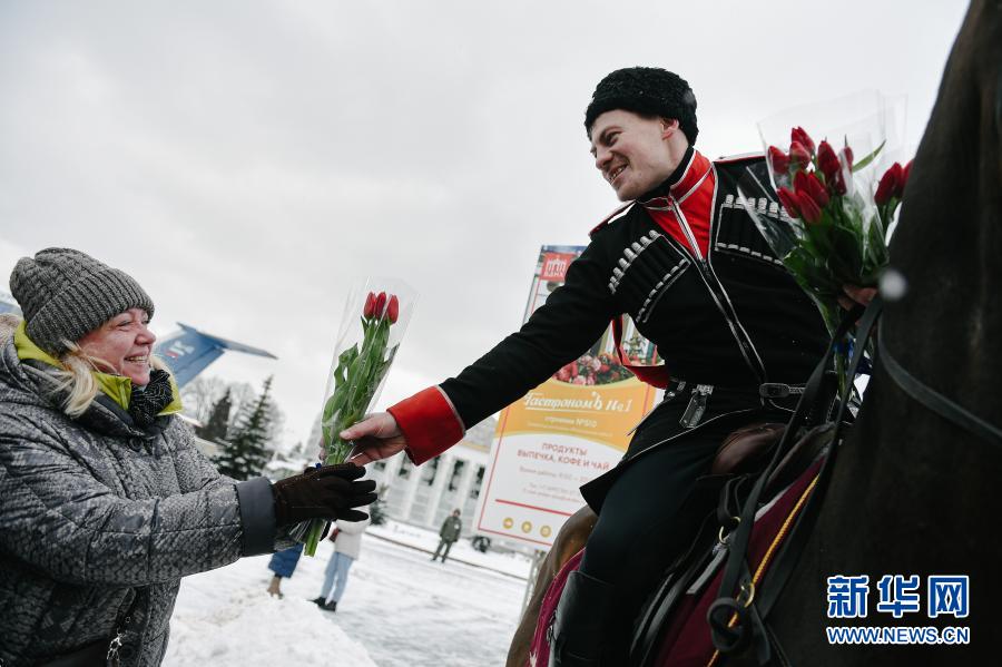 　　3月8日，骑手在俄罗斯首都莫斯科向参观者赠送鲜花。新华社发（叶甫盖尼·西尼岑摄）