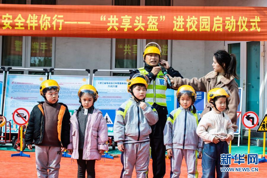 　　3月10日，交警现场演示如何正确佩戴头盔。　　当日，在浙江省湖州市织里镇晟舍幼儿园，织里镇公安分局交巡警大队启动“共享头盔进校园”活动。织里镇中小学校门口将陆续设立安全头盔共享点，内设大小头盔，家长登记后可免费取用头盔，归还后由学校负责清洁和消毒。活动旨在深入推进全镇电动车专项整治行动，普及交通安全法规，提高家长和学生们的交通安全意识。　　新华社记者 徐昱 摄