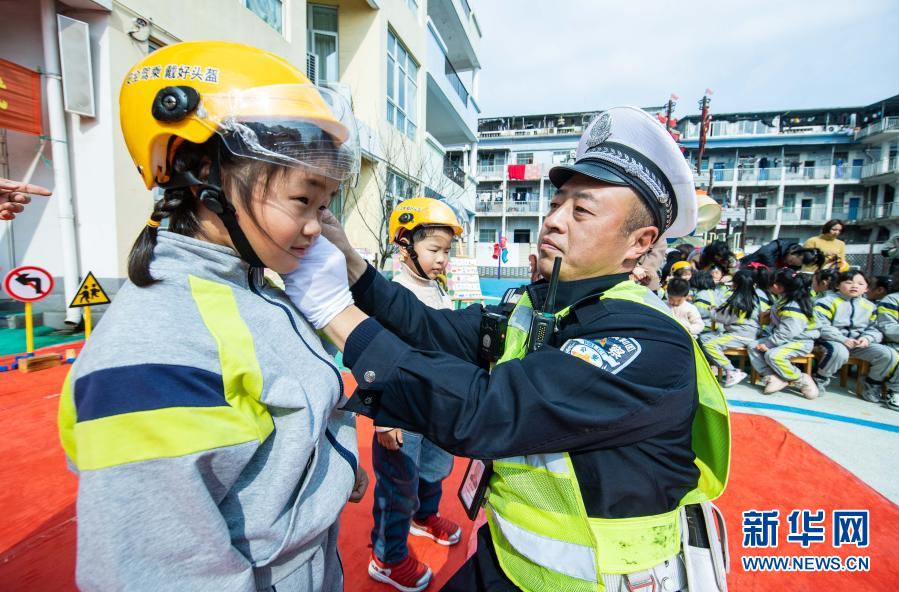 　　3月10日，交警现场指导小朋友如何正确佩戴头盔。　　当日，在浙江省湖州市织里镇晟舍幼儿园，织里镇公安分局交巡警大队启动“共享头盔进校园”活动。织里镇中小学校门口将陆续设立安全头盔共享点，内设大小头盔，家长登记后可免费取用头盔，归还后由学校负责清洁和消毒。活动旨在深入推进全镇电动车专项整治行动，普及交通安全法规，提高家长和学生们的交通安全意识。　　新华社记者 徐昱 摄