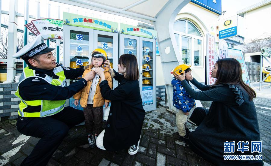 　　3月10日，交警现场指导家长和学生如何正确佩戴头盔。　　当日，在浙江省湖州市织里镇晟舍幼儿园，织里镇公安分局交巡警大队启动“共享头盔进校园”活动。织里镇中小学校门口将陆续设立安全头盔共享点，内设大小头盔，家长登记后可免费取用头盔，归还后由学校负责清洁和消毒。活动旨在深入推进全镇电动车专项整治行动，普及交通安全法规，提高家长和学生们的交通安全意识。　　新华社记者 徐昱 摄