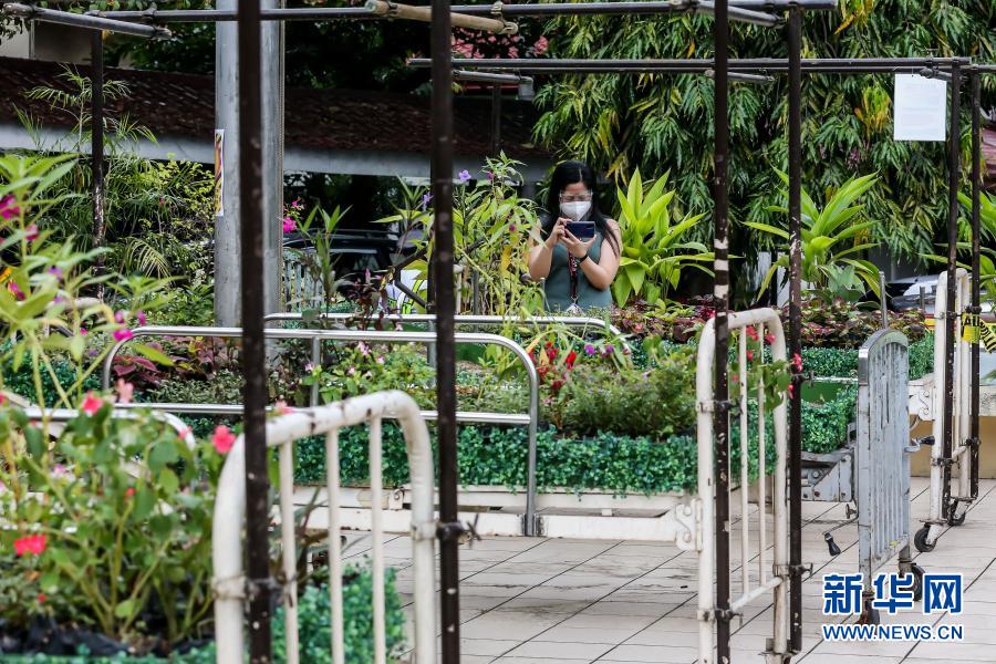 　　3月18日，在位于马尼拉的菲律宾大学附属菲律宾总医院，一名女子为“低语的花床”艺术装置拍照。　　菲律宾大学附属菲律宾总医院近日设置了一组名为“低语的花床”的艺术装置，通过在病床上铺满绿植的方式纪念在抗击新冠疫情中去世的医务工作者。这组艺术装置将于3月30日向公众展出。　　新华社发（乌马利 摄）