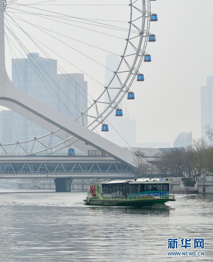 3月19日，游船载着游客在海河上穿行。当日，天津海河游船举行2021新航季首航仪式，开始接待游客。目前，天津海河游船在运营游船16艘，计划今年将新增两艘纯电动新能源游船及两艘燃油动力游船。新华社发（孙凡越 摄）