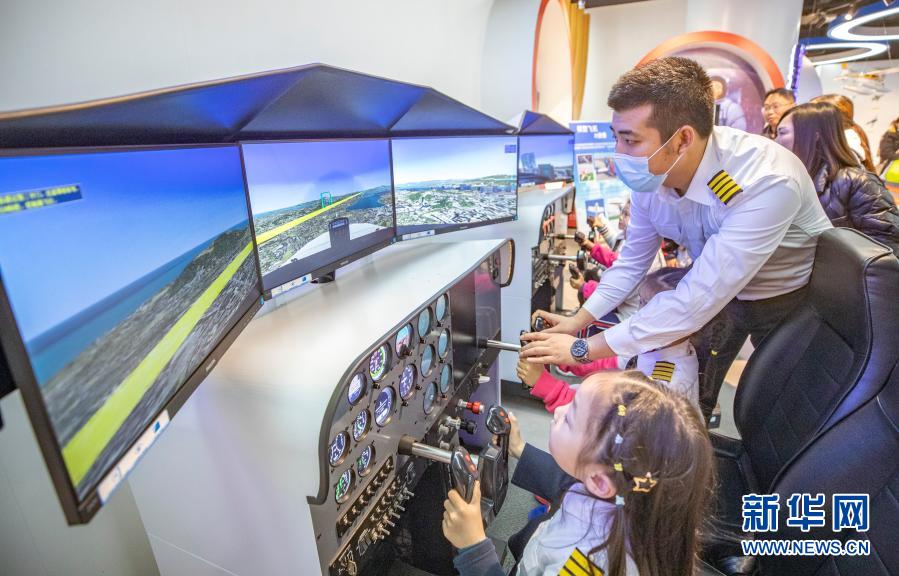 3月20日，在重庆市沙坪坝区磁器口一家航空飞行体验馆，工作人员指导小朋友体验静态模拟飞行器。新华社记者 黄伟 摄