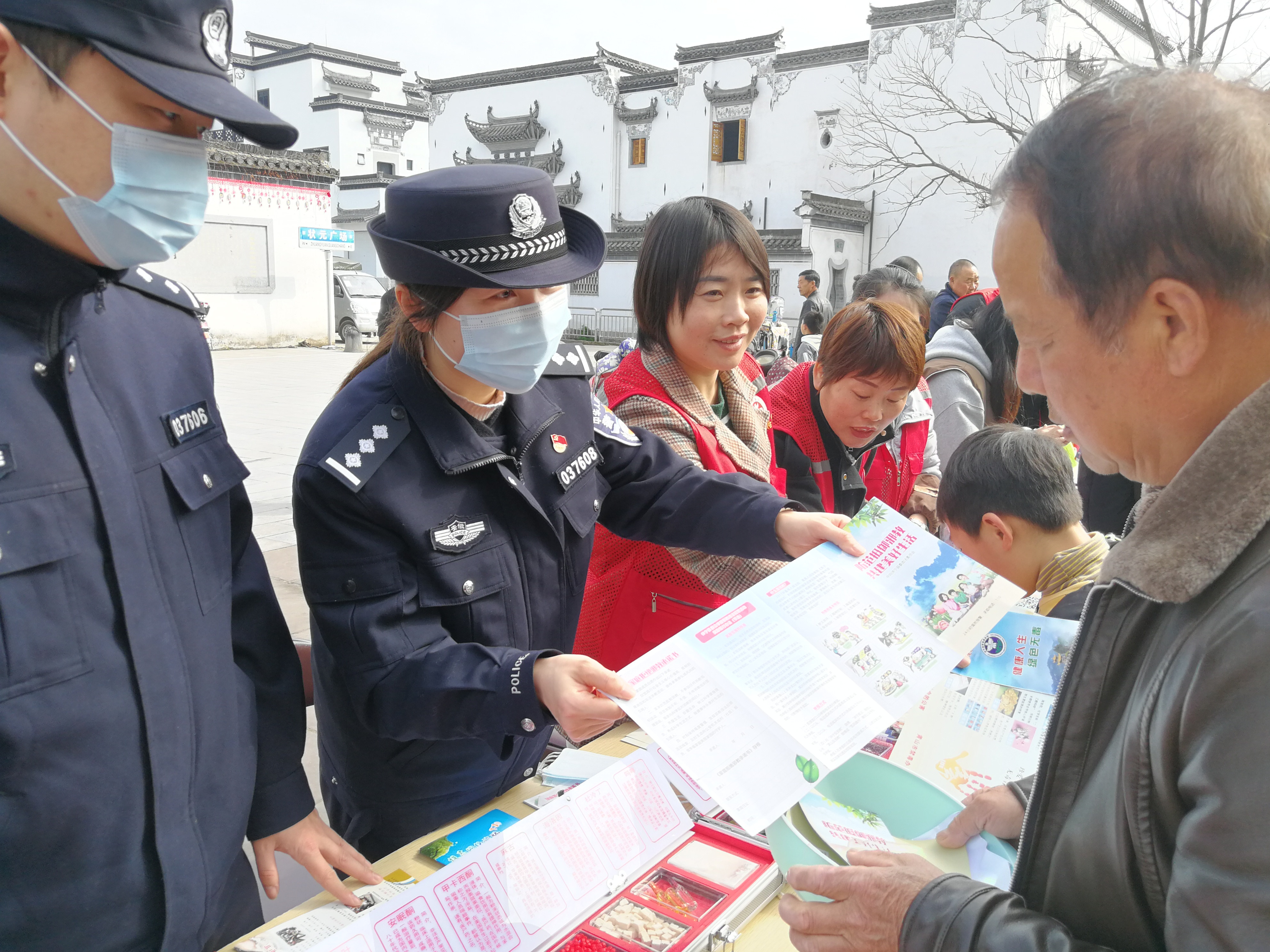 休宁县公安局民警向现场群众发放“防范抵制邪教 共建美好生活”宣传册