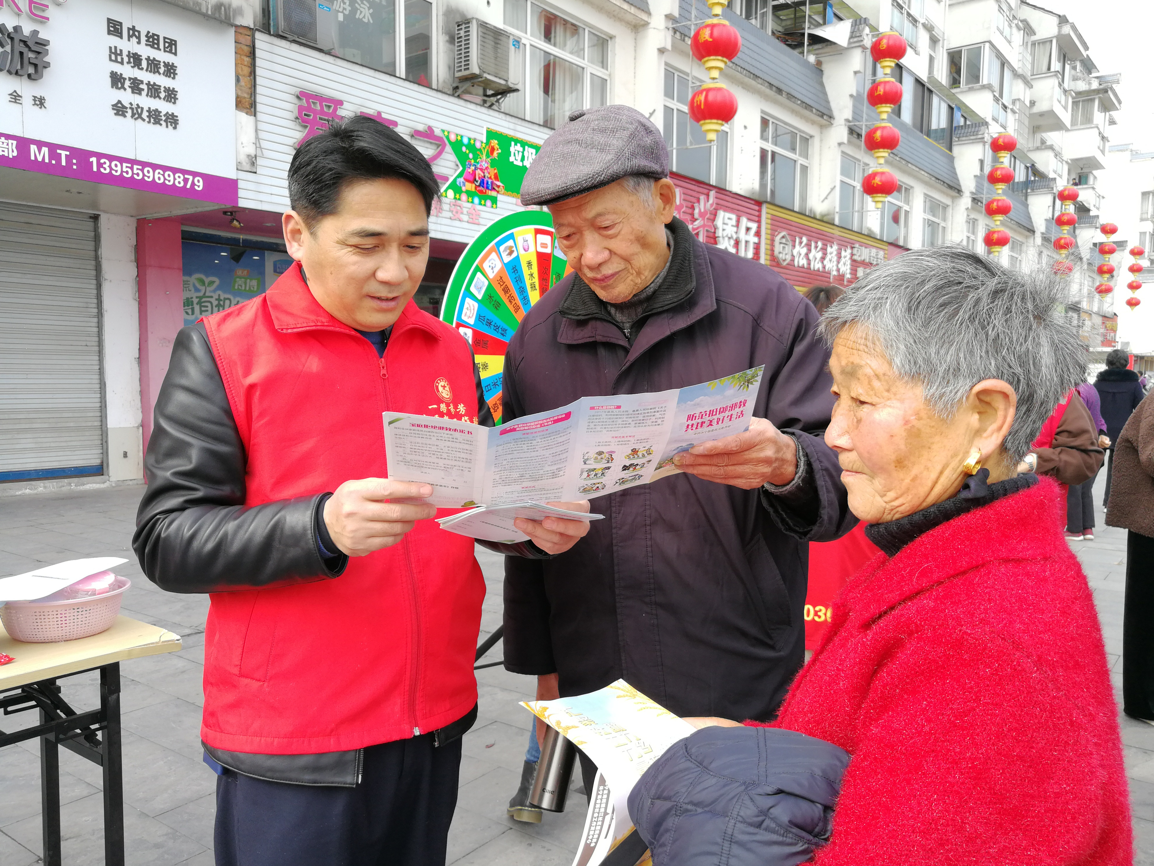 休宁县社会志愿者向群众讲解反邪教知识，告知群众邪教的危害性