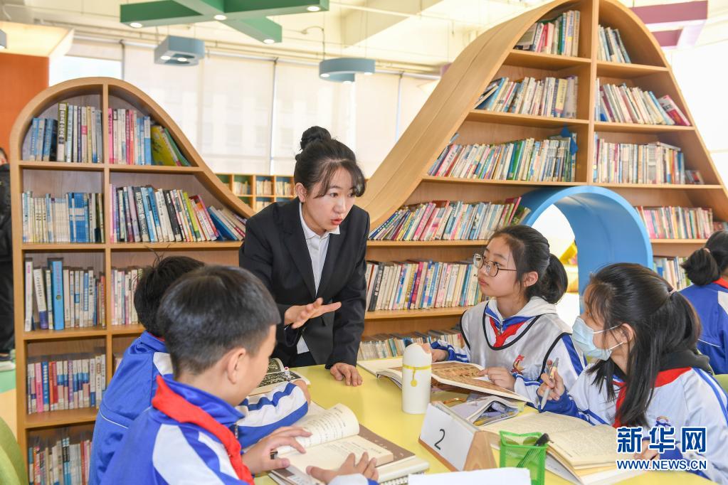 　　3月25日，在长春市第八十七中学图书馆，小学部教师孙铭辅导学生阅读书籍。　　长春市第八十七中学小学部从2018年开始，探索引导学生用绘画加文字的形式完成语文阅读摘抄作业，在不额外增加学生作业负担的前提下，培养学生的阅读习惯。　　新华社记者 张楠 摄