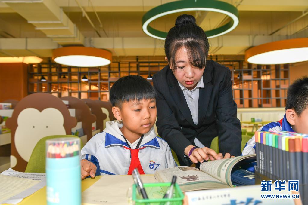 　　3月25日，在长春市第八十七中学图书馆，小学部教师孙铭辅导学生阅读书籍。　　长春市第八十七中学小学部从2018年开始，探索引导学生用绘画加文字的形式完成语文阅读摘抄作业，在不额外增加学生作业负担的前提下，培养学生的阅读习惯。　　新华社记者 张楠 摄