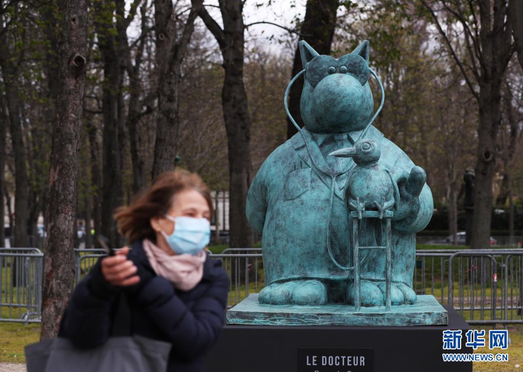 　　3月26日，一名路人走过法国巴黎香榭丽舍大街上的一尊“猫先生”铜像。新华社记者 高静 摄