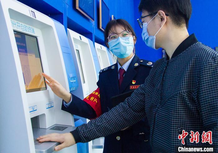 资料图:工作人员指引办税人使用自助设备。 濮志晔 摄 资料图:工作人员指引办税人使用自助设备。 濮志晔 摄