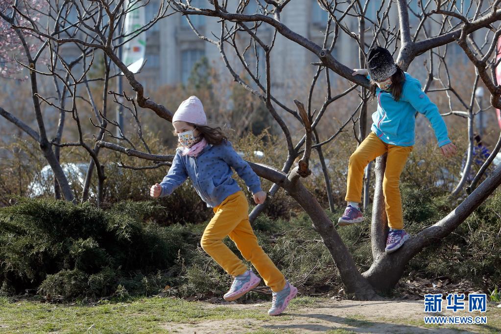 　　3月30日，孩子们戴着口罩在罗马尼亚首都布加勒斯特一处公园游玩。　　罗马尼亚正面临新一波新冠疫情，而首都布加勒斯特是全国感染率较高的地区之一。目前，罗马尼亚全国范围处于宵禁状态，每天22时至次日5时居民的出行受限，所有人出门必须戴口罩。　　新华社发（克里斯泰尔摄）