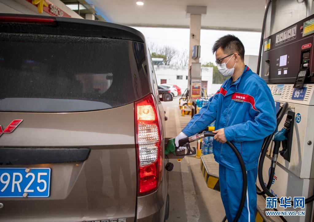 　　3月31日，江苏泰州一加油站工作人员在给汽车加油。　　在连续九次上涨后，汽油、柴油价格迎来年内首次下调。国家发展改革委3月31日称，根据近期国际市场油价变化情况，按照现行成品油价格形成机制，自31日24时起，国内汽油、柴油价格每吨分别降低225元和220元，折合每升价格下调近2角。　　新华社发（顾继红 摄）