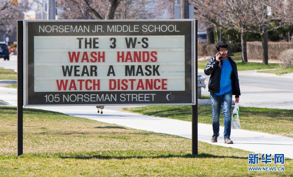 　　4月7日，一名男子从加拿大多伦多一所学校外的信息公告栏旁经过。　　为阻止新冠病毒在学校的蔓延，加拿大多伦多当日起关闭地区内的全部中小学校，教师和学生通过网络上课。　　新华社发（邹峥摄）