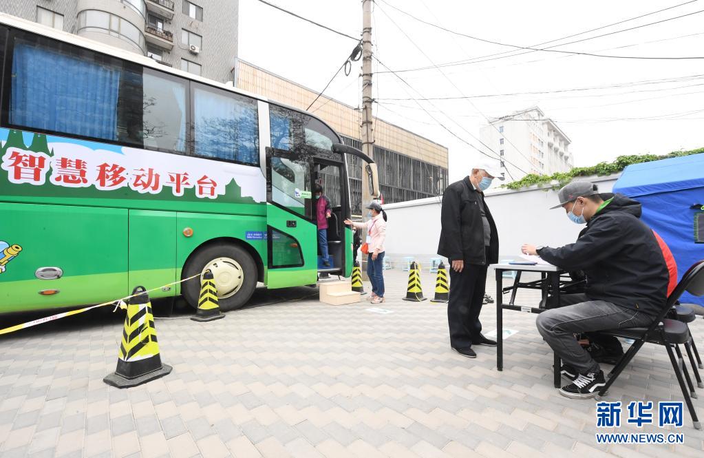 　　4月11日，在北京市海淀区羊坊店街道小马厂社区新冠疫苗临时接种点，街道工作人员（右一）为接种完新冠疫苗的接种人员填写留观卡。　　近日，北京市海淀区首辆移动疫苗接种车在羊坊店街道投入使用。据了解，该移动疫苗接种车内划分有1个登记台和2个接种台，车上配备医用冷藏箱、空调等设备，保障新冠疫苗顺利接种。　　新华社记者 任超 摄