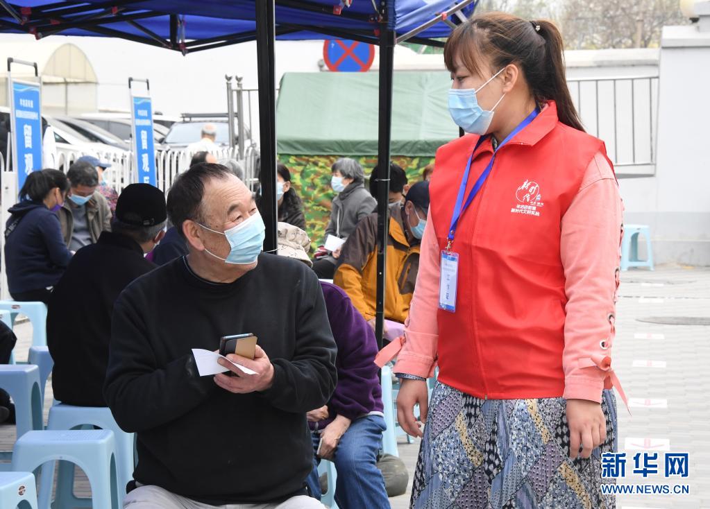 　　4月11日，在北京市海淀区羊坊店街道小马厂社区新冠疫苗临时接种点，街道工作人员（右）在留观区与接种人员交流。　　近日，北京市海淀区首辆移动疫苗接种车在羊坊店街道投入使用。据了解，该移动疫苗接种车内划分有1个登记台和2个接种台，车上配备医用冷藏箱、空调等设备，保障新冠疫苗顺利接种。　　新华社记者 任超 摄