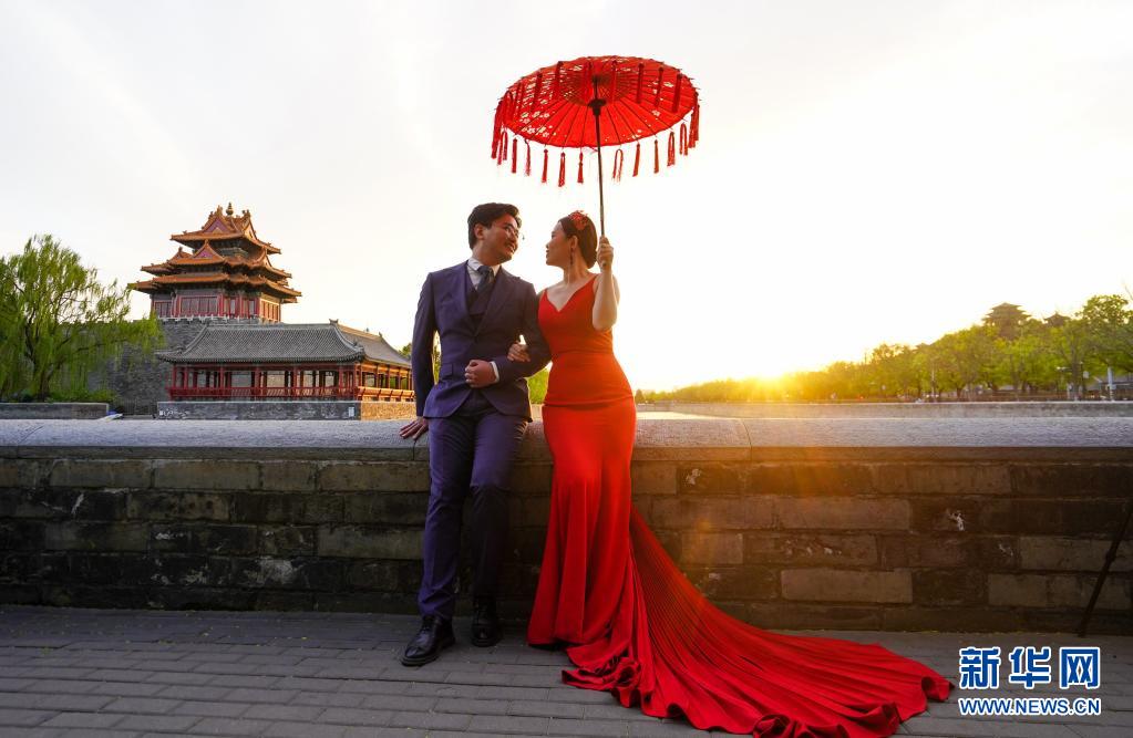 　　4月12日，一对新人在夕阳下的故宫角楼附近拍摄婚纱照。　　当日傍晚，落日余晖下的北京景美如画，别有一番意境。　　新华社记者 陈晔华 摄