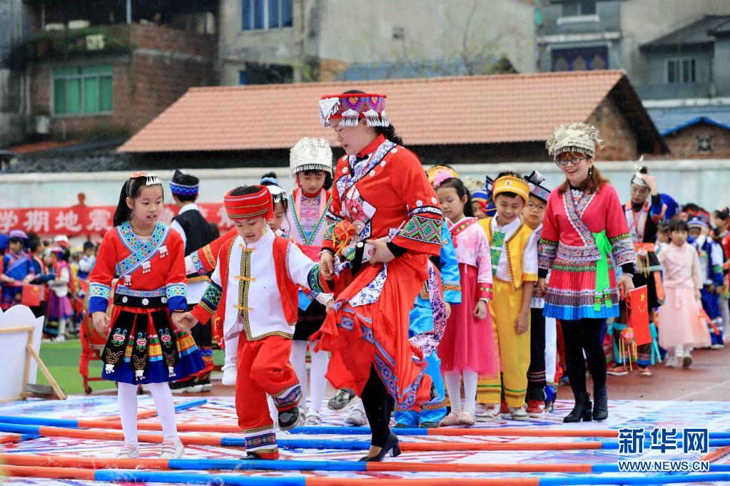 　　4月13日，在广西柳州市融安县实验小学，师生们跳竹竿舞。　　“三月三”是我国部分地区少数民族的传统节日，少数民族同胞以不同形式喜迎“三月三”。　　新华社发（谭克兴 摄）