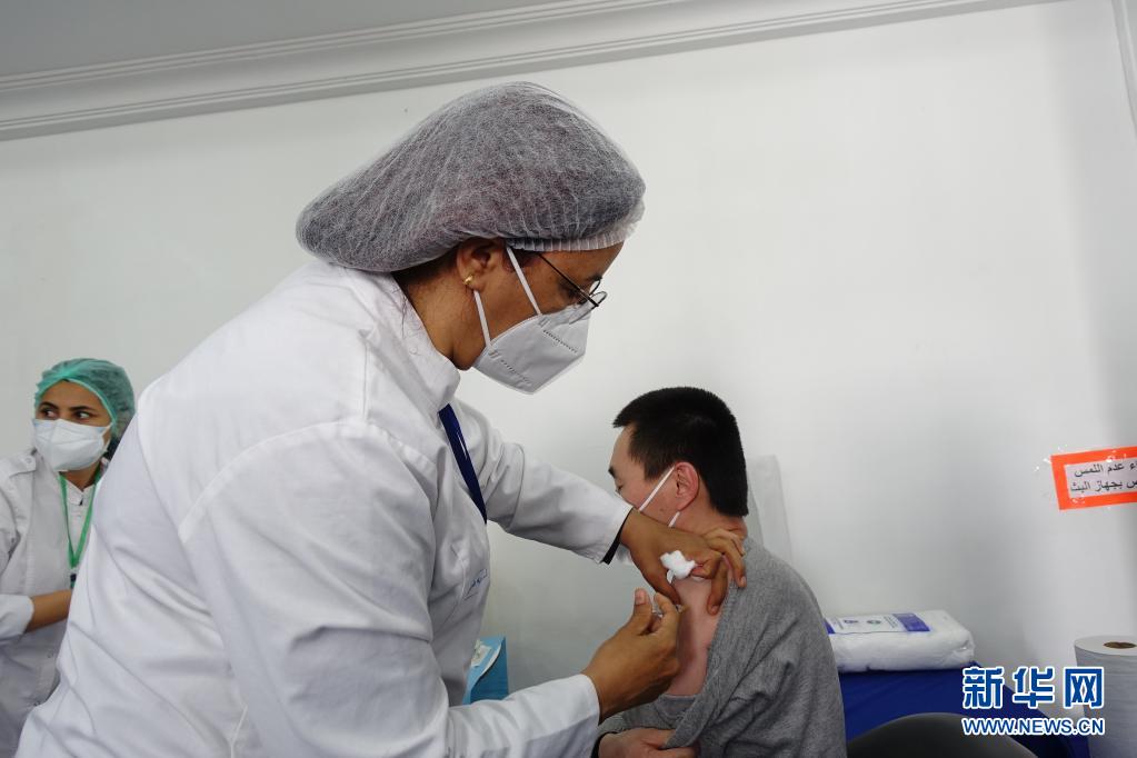 4月14日，在突尼斯首都突尼斯市，医务人员为一名中国公民接种新冠疫苗。在中国驻突尼斯大使馆协调推动下，突尼斯军事医院14日开始为中国公民接种中国科兴新冠疫苗，标志着“春苗行动”在突正式启动。新华社发