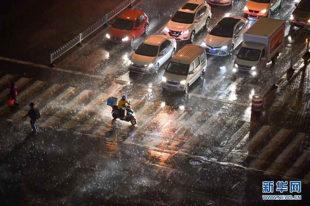 　　4月15日傍晚，在天津市南开区，外卖骑手在风雨中骑行过马路。　　当日，天津遭遇雷电风雨天气。天津市气象局于4月15日16时23分发布雷电黄色预警信号。　　新华社发（孙凡越 摄）