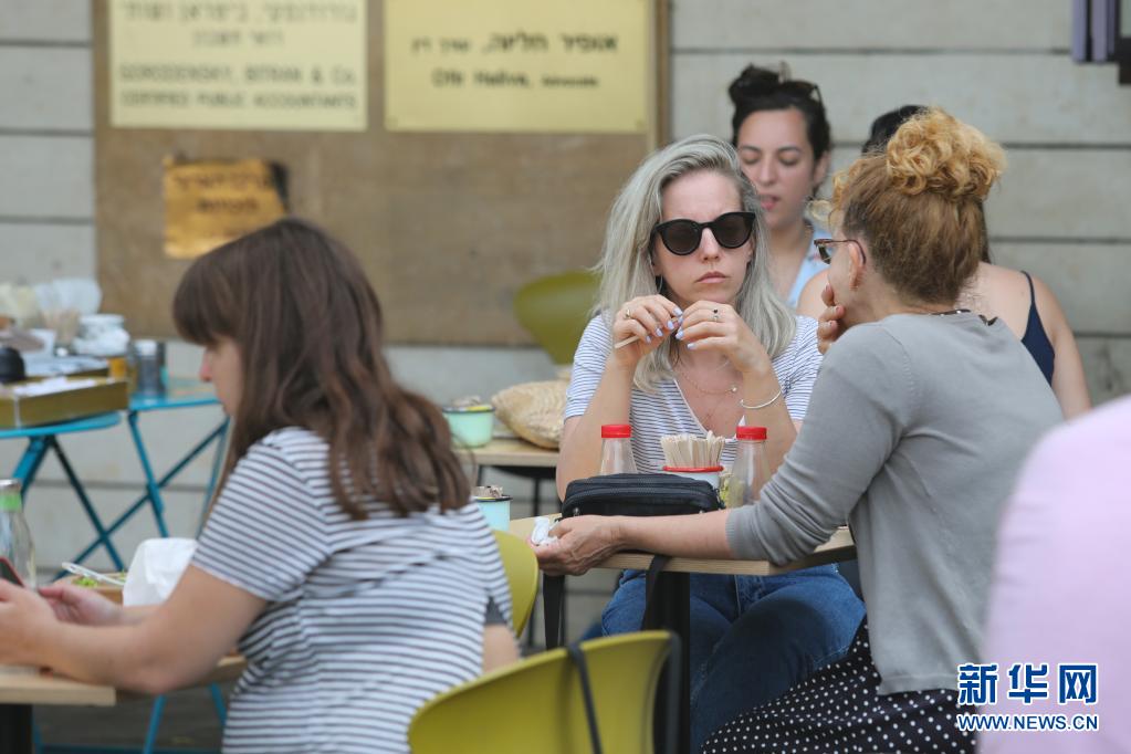 　　4月18日，人们在以色列中部城市特拉维夫户外用餐。　　得益于新冠疫苗大规模接种顺利推进，以色列民众18日起在户外场合可以不戴口罩。同一天，中小学全面恢复线下授课。　　新华社/基尼图片社