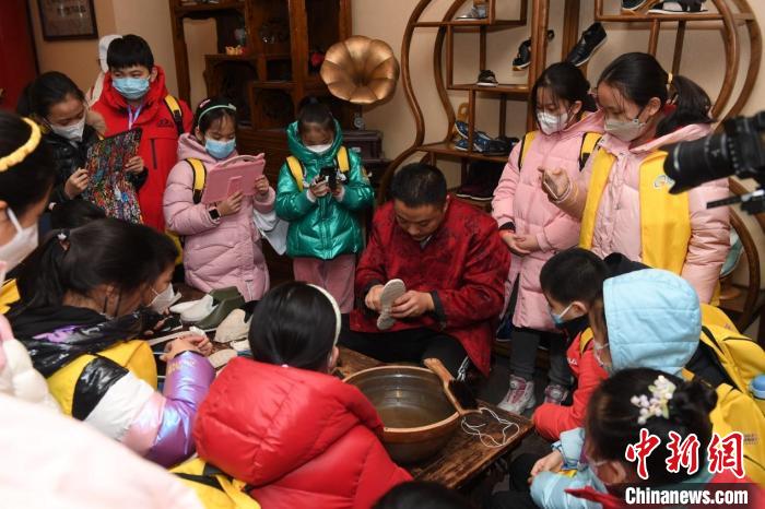 图为学员们在内联升观看、拍摄非遗技艺——千层底布鞋制作过程。 主办方供图 图为学员们在内联升观看、拍摄非遗技艺——千层底布鞋制作过程。 主办方供图