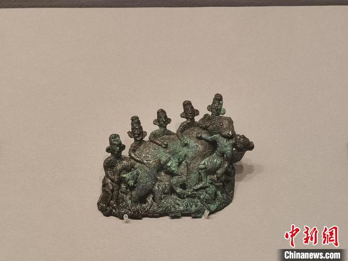 西汉时期的七人猎豹铜扣饰。　胡健 摄