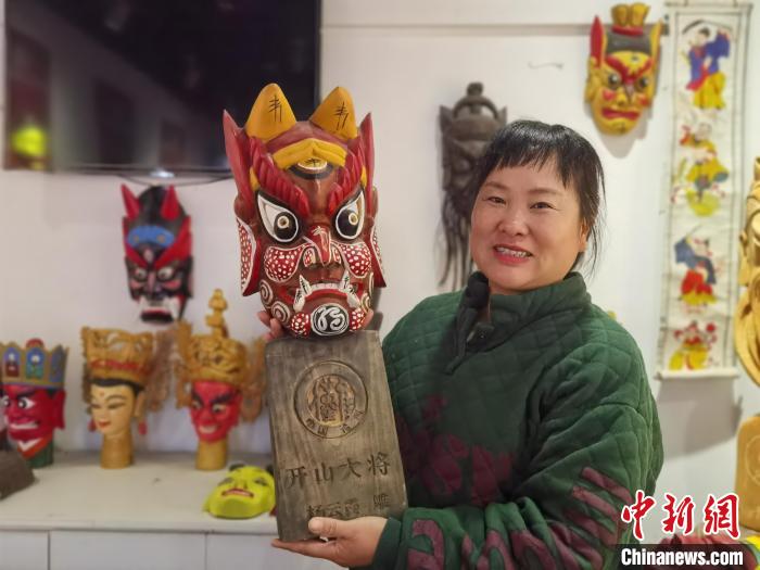 杨云霞展示自己雕刻的傩面具。　周燕玲 摄