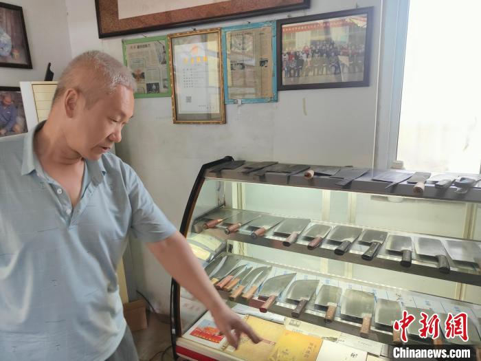 图为李记菜刀代表性传承人李留柱介绍菜刀的特点。 杨大勇 摄 图为李记菜刀代表性传承人李留柱介绍菜刀的特点。 杨大勇 摄