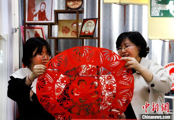 马灵雁和女儿展示剪纸作品。　杨迪 摄
