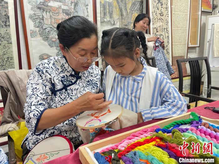 图为架花艺人正在为孩童讲解技艺。 丁茹供图 图为架花艺人正在为孩童讲解技艺。 丁茹供图