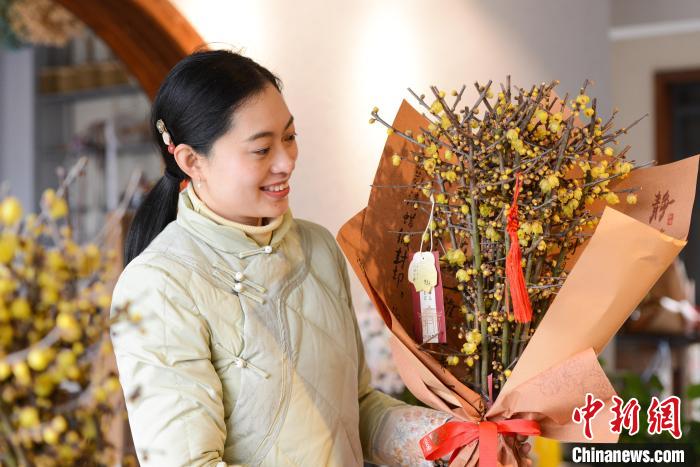 图为邓纪会正在检查制作完成的蜡梅花束。　何蓬磊 摄