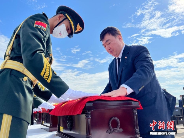 9月16日上午，中韩双方在韩国仁川国际机场共同举行在韩中国人民志愿军烈士遗骸交接仪式。图为中国驻韩国大使邢海明为志愿军烈士棺椁覆盖国旗。<a target='_blank' href='/'>中新社</a>记者 刘旭 摄